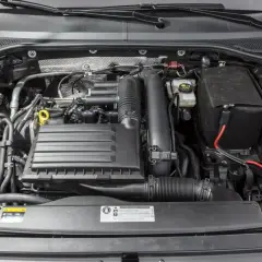 Silnik 1.4 TSI EA211 w samochodzie, z widocznym zbiorniczkiem płynu chłodniczego i innymi elementami układu.