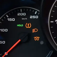 Na desce rozdzielczej świeci się kontrolka systemu TPMS, informując o niskim ciśnieniu w oponach. Obok świeci się zielona kontrolka HOLD.