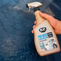 Dłoń trzyma butelkę z K2 SPID WAX, gotową do aplikacji na mokry lakier samochodowy. Produkt ten nie jest octem, lecz woskiem.