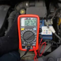 Jak sprawdzić napięcie miernikiem w samochodzie? Oto wynik 12.72V na wyświetlaczu multimetru, podłączonego do akumulatora.