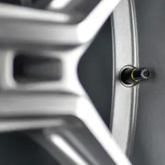 Zbliżenie na felgę aluminiową z widocznym wentylem. Różne rodzaje wentyli samochodowych zapewniają szczelność opony.