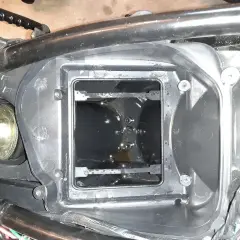 W obudowie filtra powietrza motocykla widać ciemny olej w odmie.