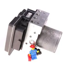 Moduł ABS z małym ludzikiem z klocków LEGO, który trzyma czerwoną skrzynkę narzędziową.