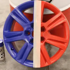 Felga aluminiowa podzielona na dwie części: niebieską i czerwoną. Obok puszki z farbą K2 Color Flex, pokazujące czym pomalować felgi aluminiowe.
