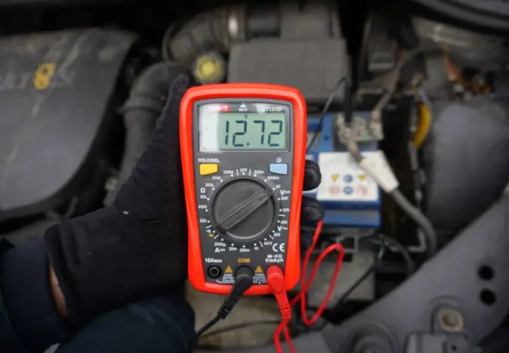 Jak sprawdzić napięcie miernikiem w samochodzie? Oto wynik 12.72V na wyświetlaczu multimetru, podłączonego do akumulatora.