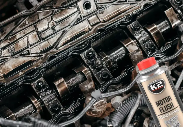 Brudny silnik czeka na płukanie. Butelka K2 Motor Flush z czerwoną nakrętką sugeruje odświeżenie.