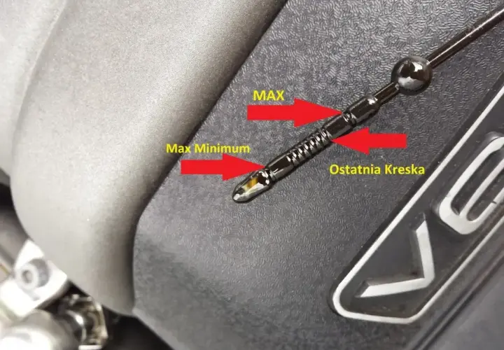Jak odczytać poziom oleju na bagnecie: poziom oleju jest między "Max" a "Ostatnia Kreska", co oznacza prawidłowy stan.