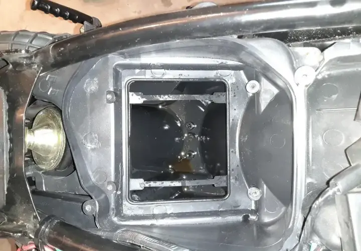 W obudowie filtra powietrza motocykla widać ciemny olej w odmie.