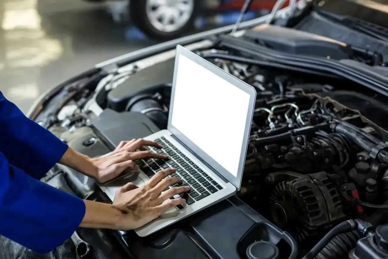 Mechanik diagnozuje przyczyny dławienia się silnika przy dodawaniu gazu, analizując dane z komputera.