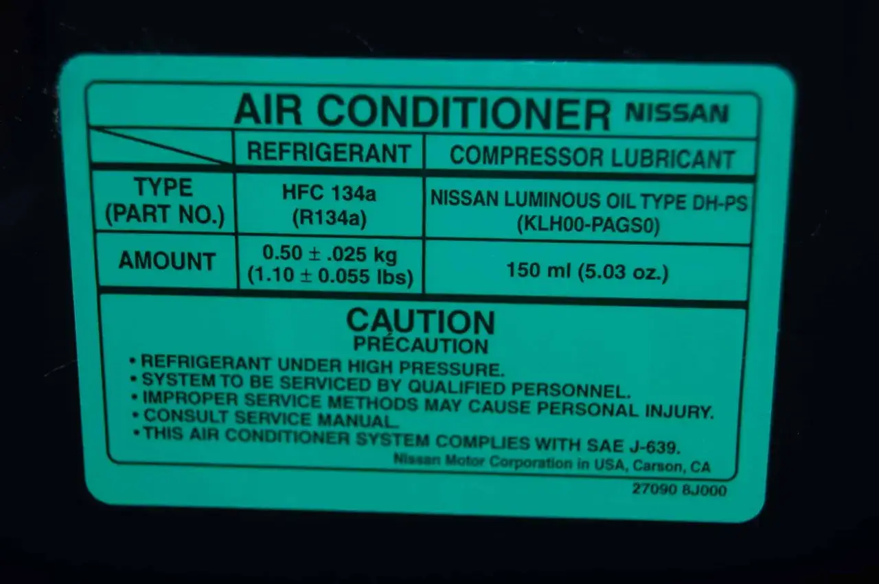 Naklejka Nissan podaje ilość czynnika klimatyzacji: 0.50 &plusmn;.025 kg (1.10 &plusmn; 0.055 lbs) oraz olej 150 ml.