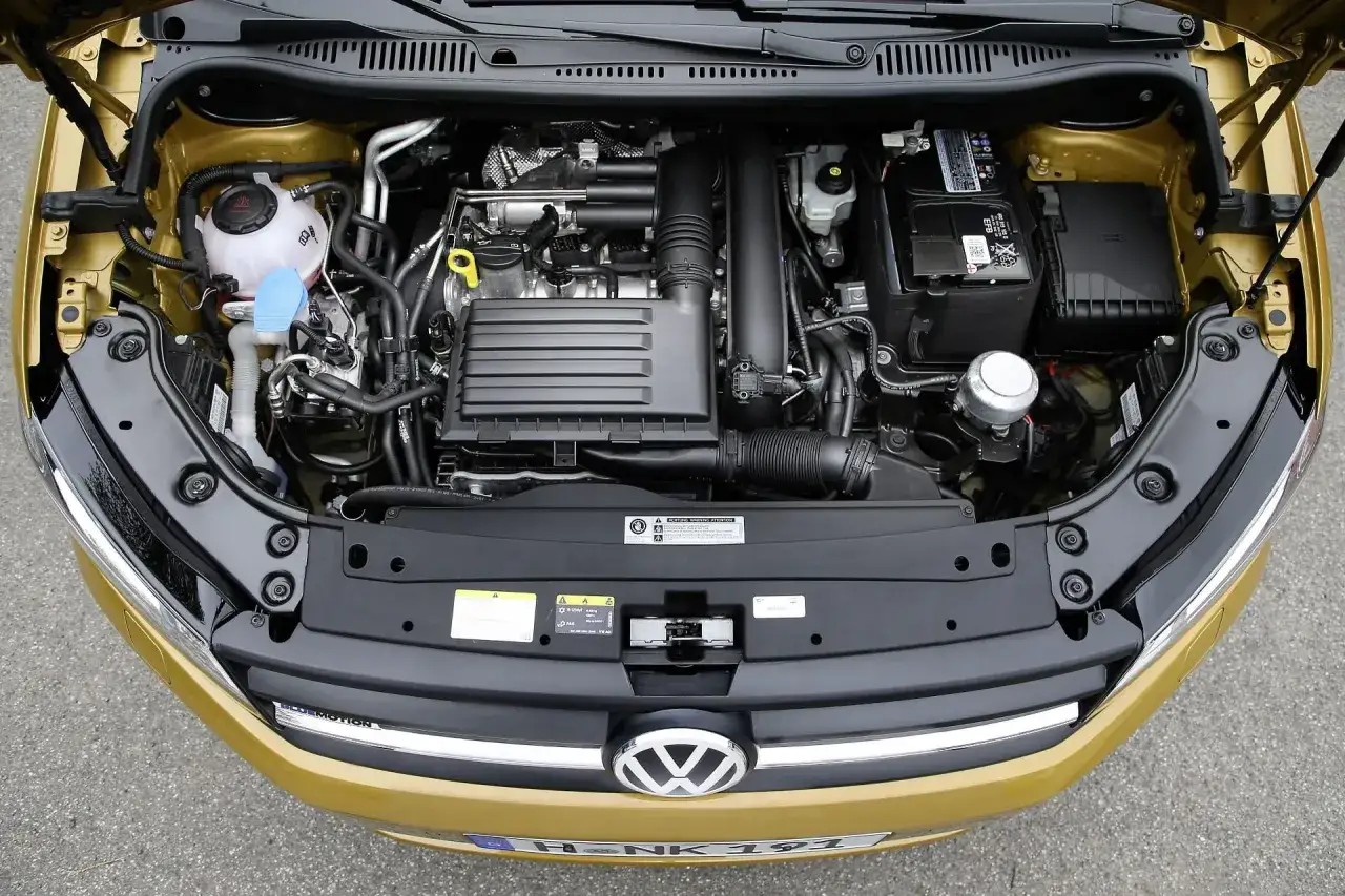 Silnik 1.4 TSI EA211 w złotej karoserii, widok z g&oacute;ry. Widać turbosprężarkę, akumulator i płyny eksploatacyjne.